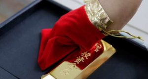 A sales assistant displays a 1000 gram gold bar as an investment for a customer at Caibai Jewelry store, in Beijing, China, August 6, 2019. REUTERS/Jason Lee - RC1CF5DEDCD0