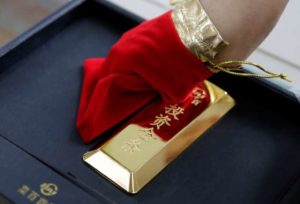 A sales assistant displays a 1000 gram gold bar as an investment for a customer at Caibai Jewelry store, in Beijing, China, August 6, 2019. REUTERS/Jason Lee - RC1CF5DEDCD0